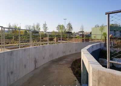 Garde-corps en filet inox 60x104 mm suivant la courbe d’un muret en béton, assurant protection et transparence.