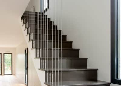 Garde-corps inox à câble tendu vertical installé dans un escalier contemporain